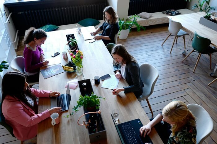 Frauen sitzen an einem Tisch im Coworking