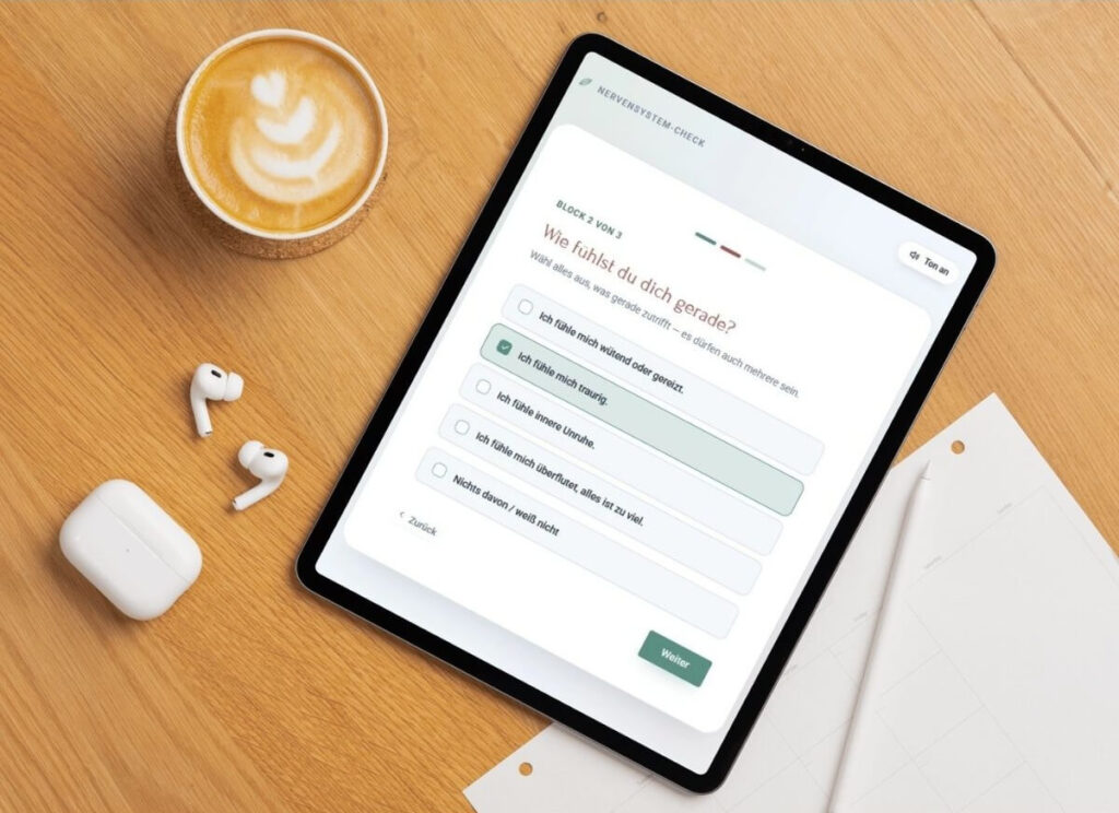 tablet, auf dem der nervensystem-check zu sehen ist und eine tasse kaffee